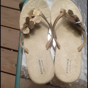 Sandals with gold flower embellishments.